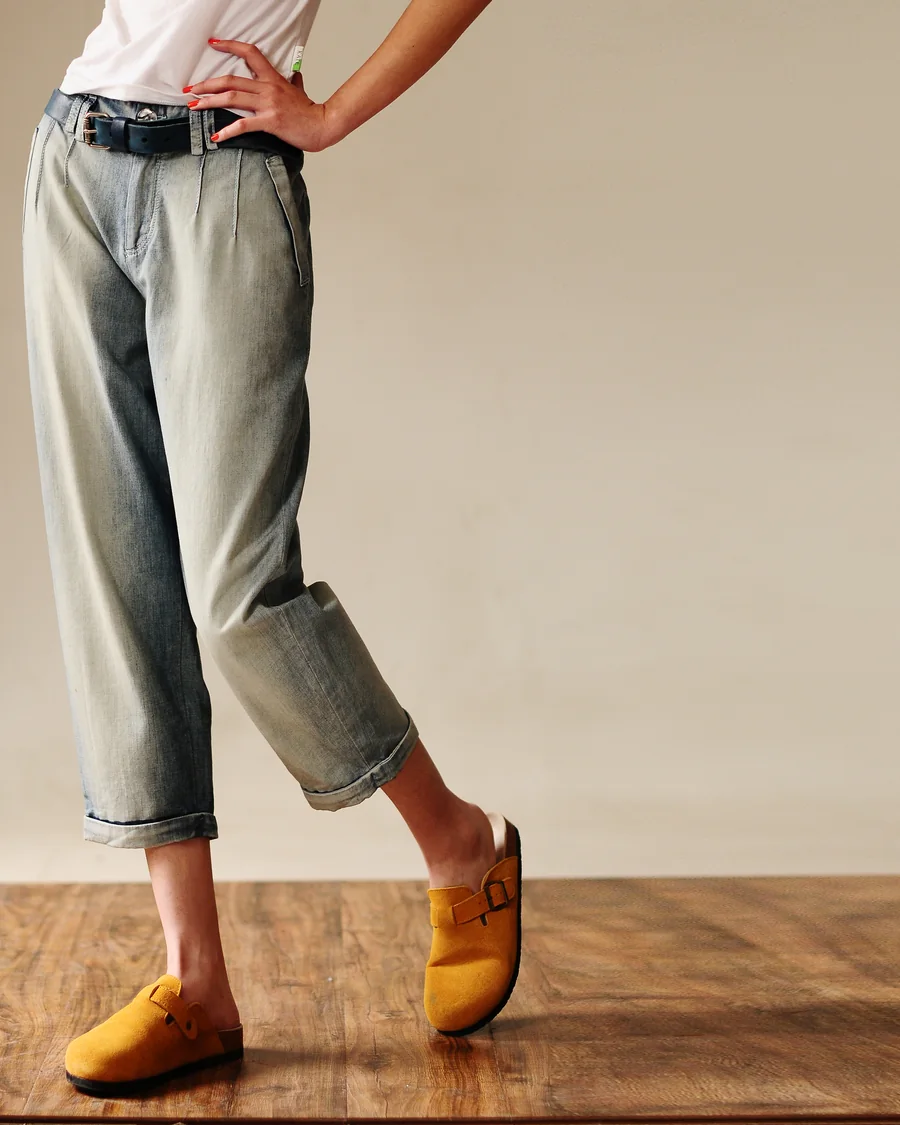 Cropped light-wash jeans with a turned hem on a wood floor