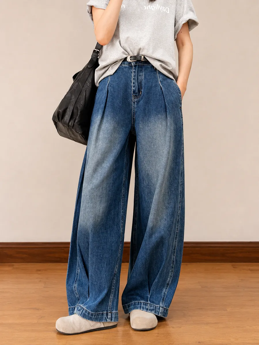 Pleated wide-leg indigo jeans with a soft fade, studio floor